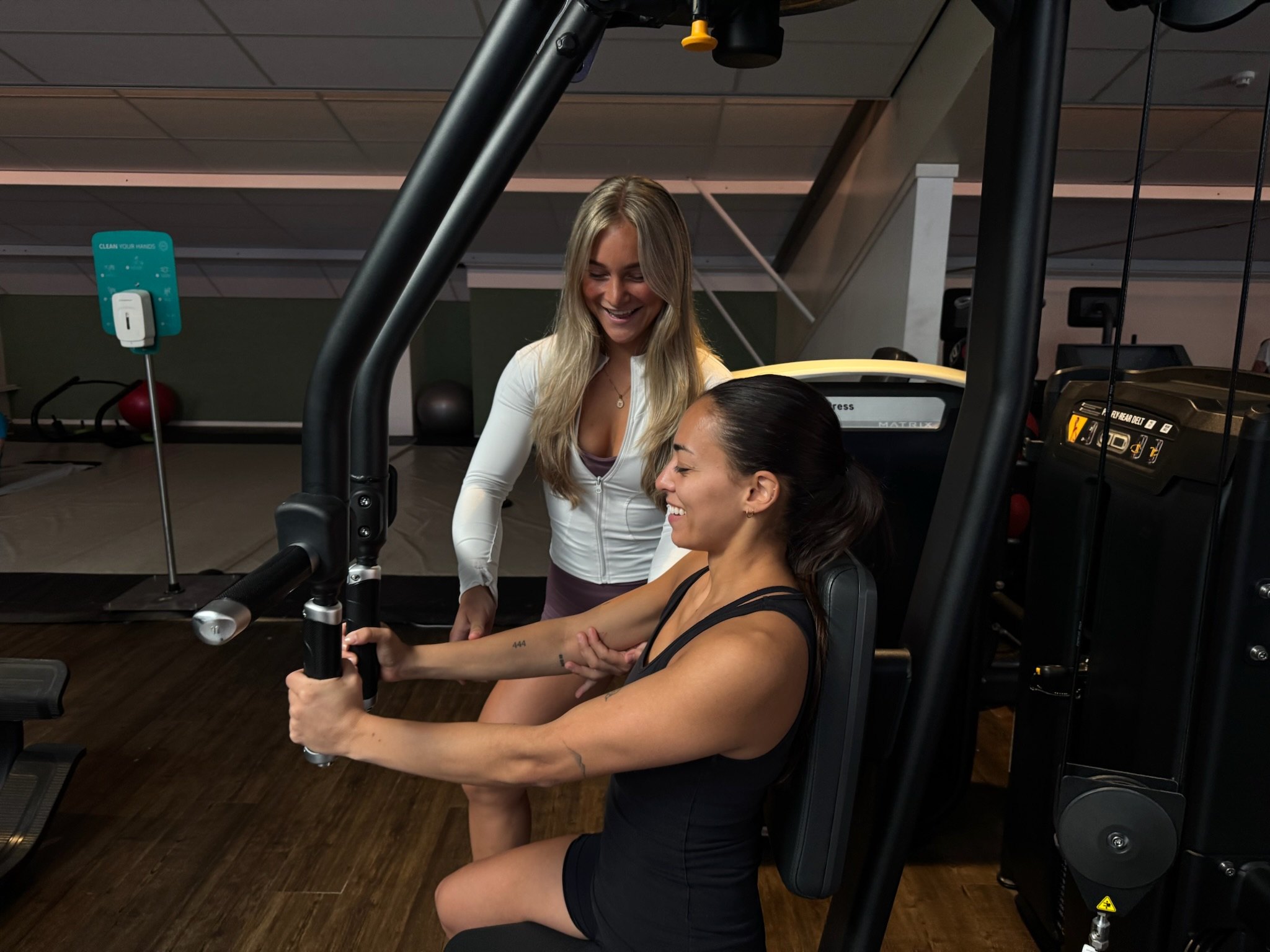 Ebony begeleidt een klant op de chest press bij Sportcentrum Hoorn